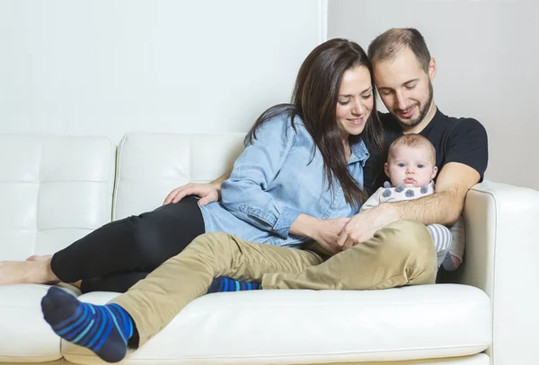 英俊的年轻父亲和母亲用可爱刚出生的婴儿，在沙发上 — 图库照片