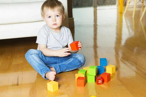 Niño jugando bloques de juguete dentro de su casa —  Fotos de Stock