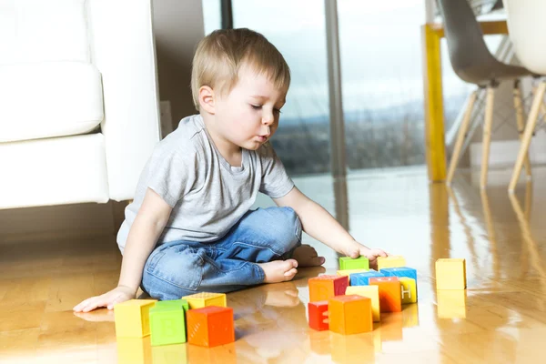 Niño jugando bloques de juguete dentro de su casa —  Fotos de Stock