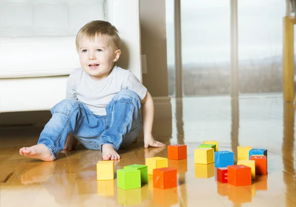 Criança jogando blocos de brinquedo dentro de sua casa — Fotografia de Stock
