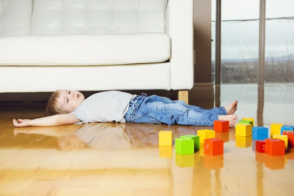 Ребенок играет игрушечные блоки в своем доме — стоковое фото