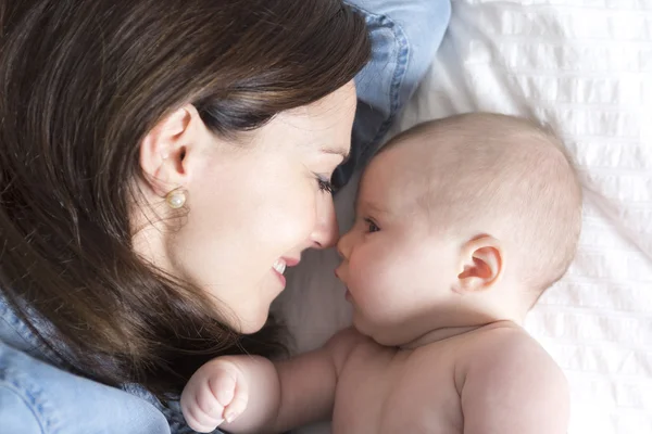 Baba és az anya jó időt fehér ágy — Stock Fotó