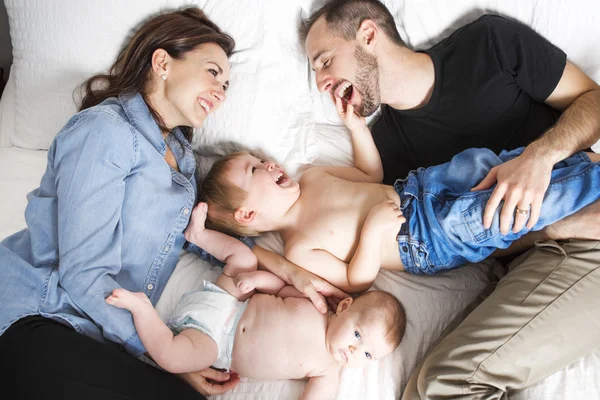 Счастливая семья лежит в постели — стоковое фото