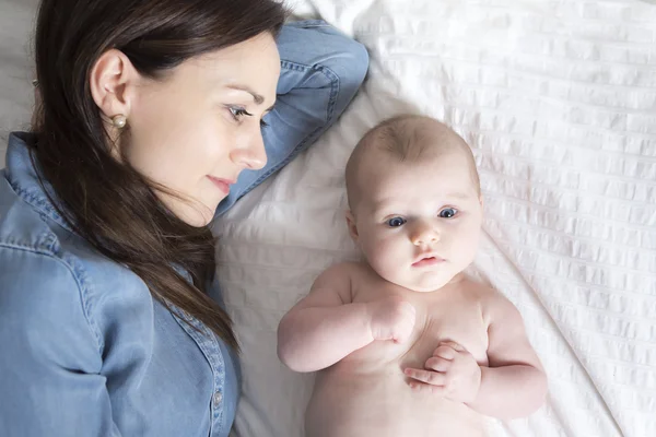 Bayi dan ibu di tempat tidur putih mengambil waktu yang baik — Stok Foto