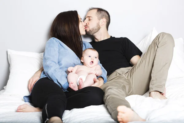 Amare i genitori con la loro bambina carina sul letto — Foto Stock