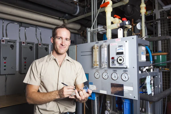 Technician inspecting heating system in boiler room — Stock Photo, Image