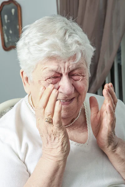 Senior woman laughing out loud in living room — Stock Photo, Image