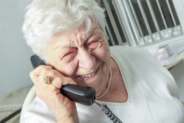 Elderly woman speaks on the phone — Stock Photo, Image