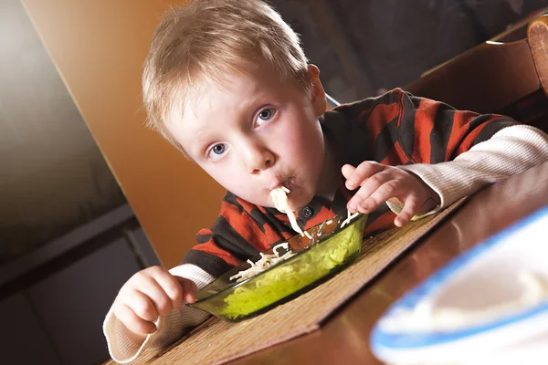 Kleine jongen eten pasta binnen de twee jaar. Peuter kind in binnenlandse keuken — Stockfoto