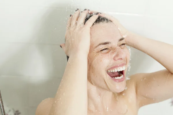 Ducha mujer. Feliz mujer sonriente lavándose el hombro duchándose en —  Fotos de Stock