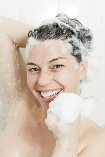 Ducha mujer. Feliz mujer sonriente lavándose el hombro duchándose en —  Fotos de Stock