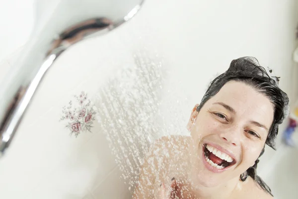 Душ жінка. Щаслива усміхнена жінка миє плече душ в — стокове фото
