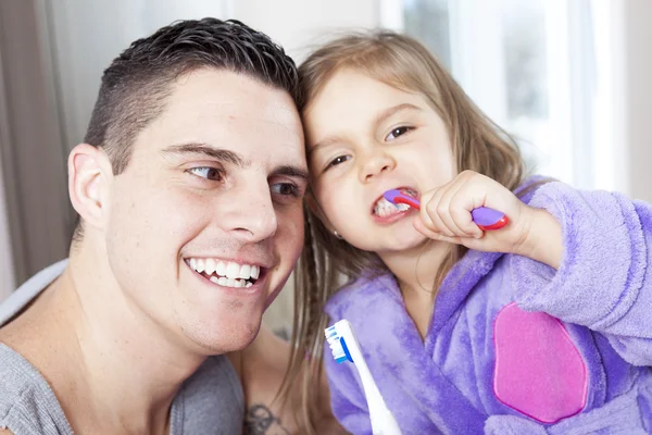 Vader met zijn dochter tanden in de badkamer schoon te maken — Stockfoto