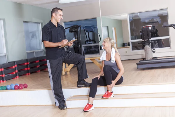 Gym vrouw persoonlijke trainer man met gewicht trainingsapparatuur — Stockfoto
