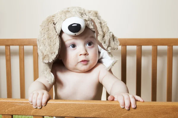 Petit bébé drôle avec une belle debout dans une crèche ronde blanche — Photo