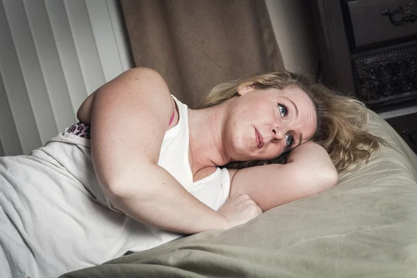 Une femme se sent malade allongée sur son lit — Photo