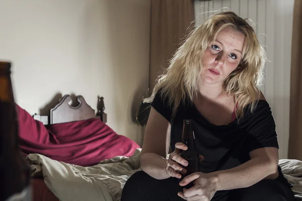 A alcoholic woman drinking beer in his bedroom. — Stock Photo, Image