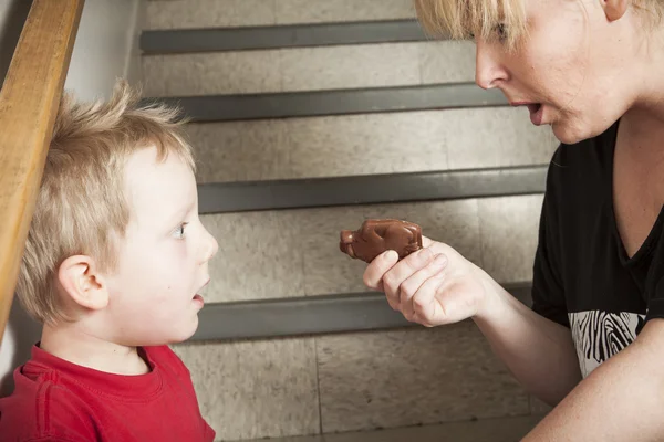 Portret van de familie van zoon feed zijn moeder chocolade bar — Stockfoto