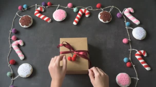 Hände halten Weihnachtsgeschenkschachtel mit handgemachten Weihnachtsstöcken auf dunklem Hintergrund — Stockvideo