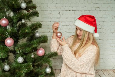 Noel ağacını pembe ve gümüş mücevherlerle süslemek, Noel ağacını süsleyen tatlı genç kız.