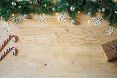 Noel ağacı dallarıyla süslenmiş ahşap bir fırın. El yapımı Noel süsleri, süsler, kar taneleri, şeker kamışları ve içinde fotokopi alanı olan hediye kutusu.