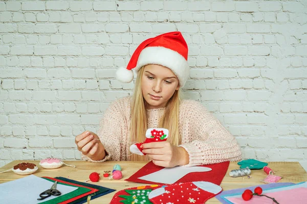 Дій Різдвяний панчіх, дівчина шила ручної роботи відчувала різдвяну шкарпетку — стокове фото