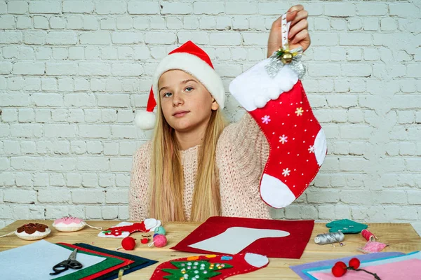 Дій Різдвяний панчіх, дівчина тримає ручної роботи відчував різдвяний шкарпетку — стокове фото