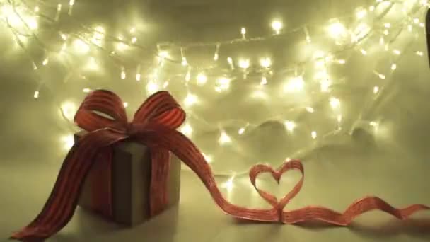 День Святого Валентина подарункова коробка з червоною стрічкою лук і серце на фоні боке — стокове відео