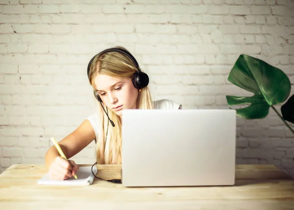 English online lesson, teenage girl wearing headphones studying online