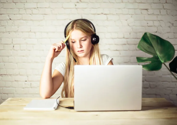 English online lesson, teenage girl wearing headphones studying online