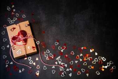 Sevgililer günü için pullu kalple dolu bir hediye kutusu. Arka planda kalp pulları var.