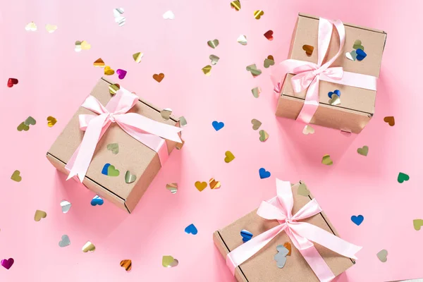 Cajas de regalo rosadas con confeti en forma de corazón sobre fondo rosa —  Fotos de Stock