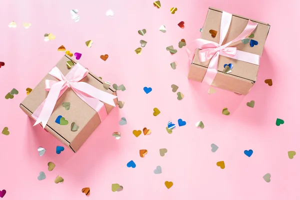 Cajas de regalo rosadas con confeti en forma de corazón sobre fondo rosa —  Fotos de Stock