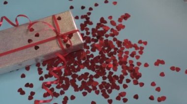 Kalp şeklinde konfeti mavi arka plandaki hediye kutusuna düşer.