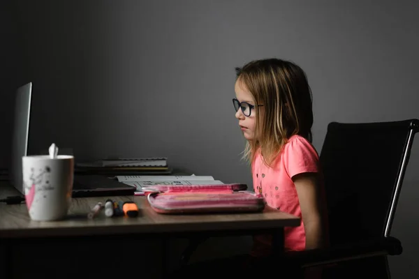 Menina em óculos estudando online e usando seu laptop em casa — Fotografia de Stock