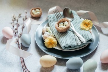 Paskalya sofrası kurma fikirleri, asgari dekorasyon - Paskalya yumurtaları, söğüt dalları, açık gri arka planda kuş yuvası, fotokopi alanı üst görünümü
