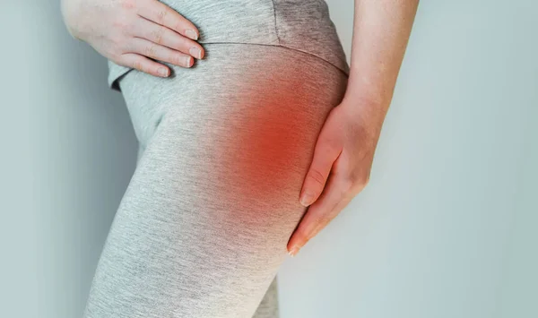 Eine Frau leidet am Piriformis-Syndrom, Schmerzen im Gesäßmuskel — Stockfoto