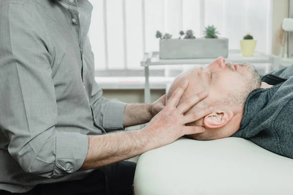 Ostheopatic treatment of a patient using CST gentle hands-on technique, central nervous system tension relieve used for eliminating pain and boosting health and immunity — Stock Photo, Image