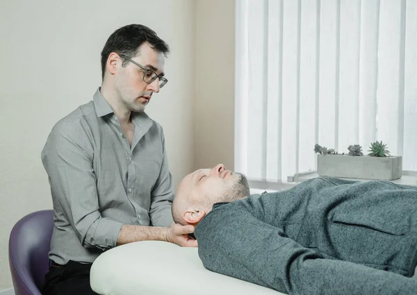CST practitioner uses gentle pressure to relieve the stress and pain caused by compression, cranial sacral treatment, osteopathy and manual therapy — Stock Photo, Image