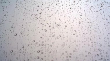 Yağmurlu bir günde pencere camından damlayan yağmur damlaları.