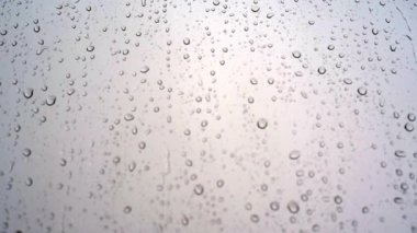 Yağmurlu bir günde pencere camından damlayan yağmur damlaları.