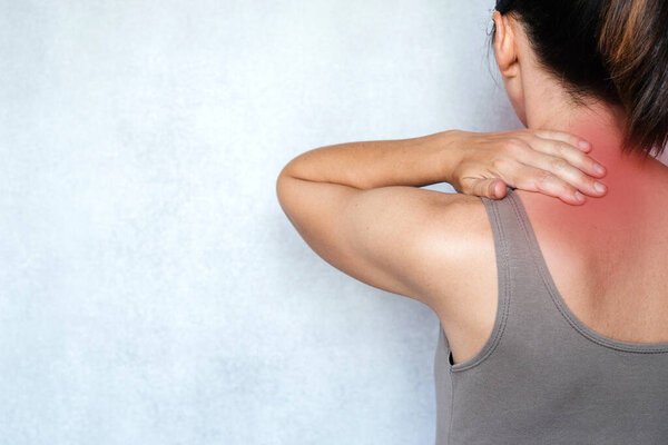 A woman suffering from neck pain and massaging her neck to releive pain, neck pain relief exercises