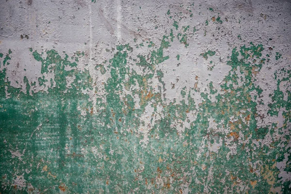 Old green metal surface with cracked paint texture close up background