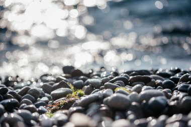Kumsal çakıl taşları kıyıya vuran köpüklü dalgalar sakin ve sakin yaz arkaplanı, Akdeniz 'in temiz deniz suyu sabah