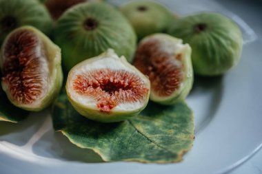 Olgun taze incir meyveleri ve beyaz arka planda yaprak, yaz egzotik meyveler.