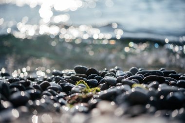 Kumsal çakıl taşları kıyıya vuran köpüklü dalgalar sakin ve sakin yaz arkaplanı, Akdeniz 'in temiz deniz suyu sabah