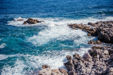 Açık turkuaz dalgalar, güpegündüz Sicilya kıyı şeridi boyunca engebeli kayalara çarpıyor. Seyahat, doğa ve Akdeniz yaşam tarzı kavramları için ideal