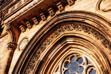 Glasgow Üniversitesi 'nin karmaşık gotik taş oymaları ve kavisli pencerelerine yakın plan, sıcak güneş ışığıyla işaretlenmiş. Mimarlık, miras ve zanaat teması için mükemmel.