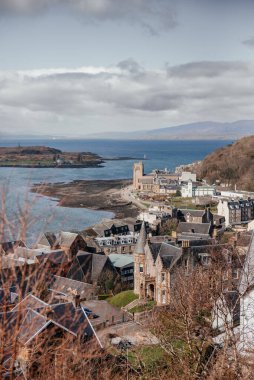 İskoçya 'nın Oban kentinin manzarası, limanı, feribot terminalini, çevresindeki kenti ve uzak kıyı manzarasını gösterir. Seyahat ve turizm temaları için mükemmeldir.