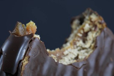 Isırılmış çikolata kaplı kurabiye, karamel dolgusunu gösteriyor.